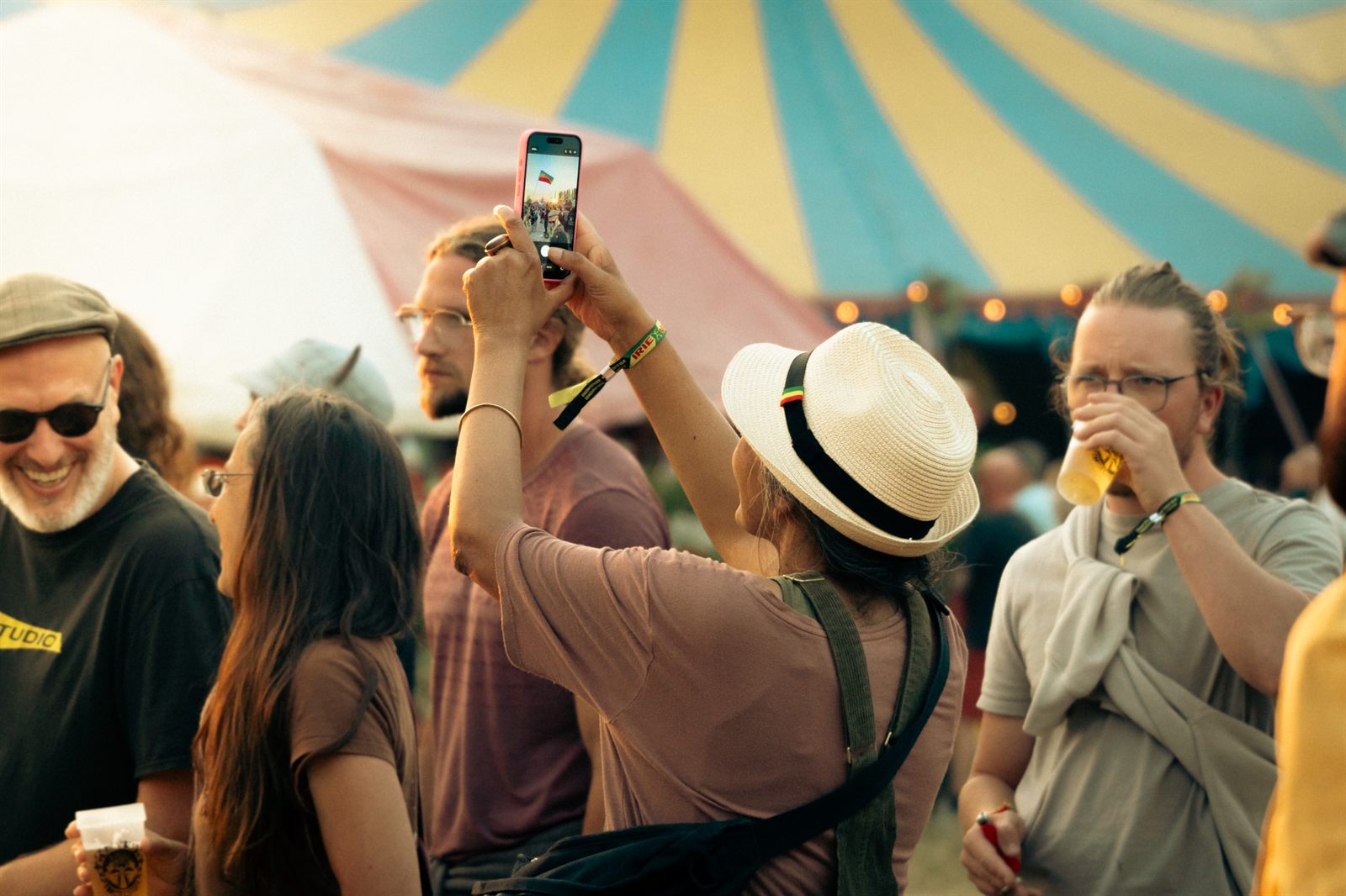 Publiek dat foto's maakt onder de gestreepte tent