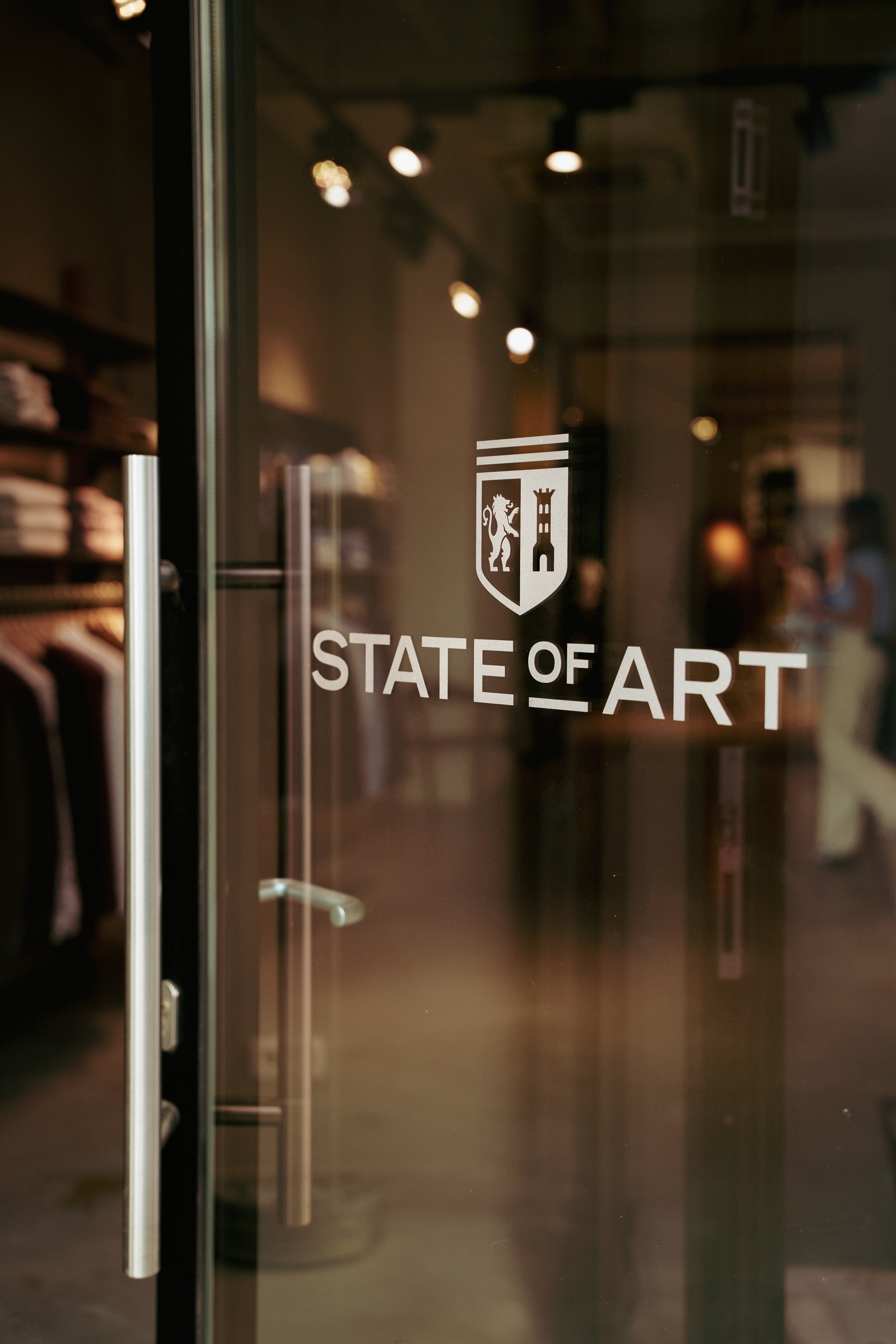 Glazen deur van de State Of Art-winkel met het logo
