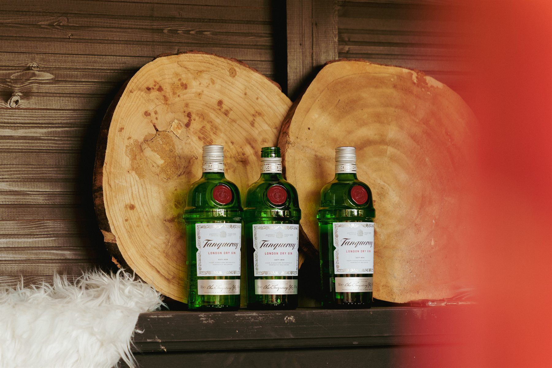 Drie flessen gin voor houten boomschijven