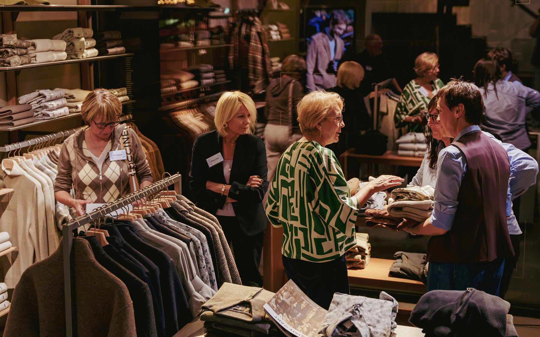 Gasten die tussen de kleding rondkijken en praten